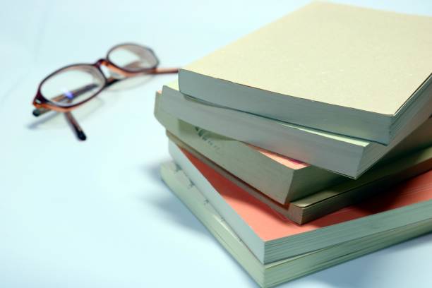 istock Stacked books and glasses 1187117947