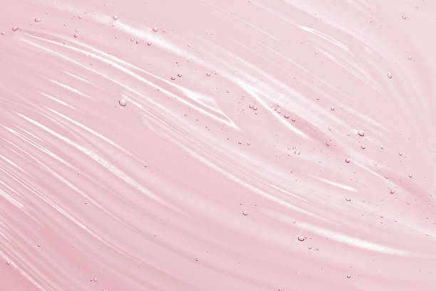 Pink cosmetic gel background Serum, liquid gel texture. Clear cosmetic cream background. Transparent pink colored skincare product smudge lotion texture stock pictures, royalty-free photos & images