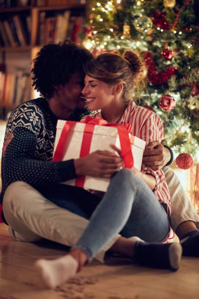 istock Romantic couple opening a present on a Christmas 1187121587