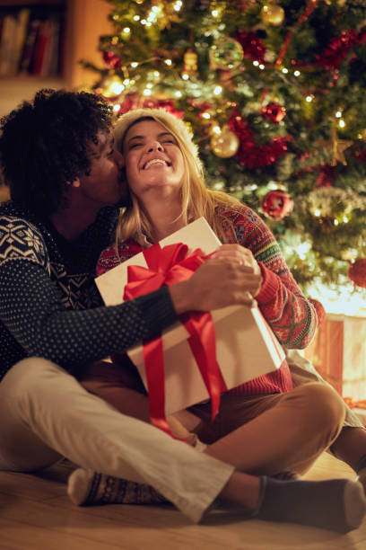 istock Smiling male and female exchanging Christmas presents 1187121663