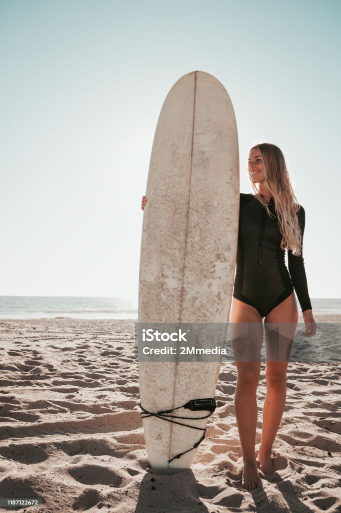 junge Frau steht mit Surfbrett am Strand von Malibu. California Lebensstil - Lizenzfrei Brandung Stock-Foto