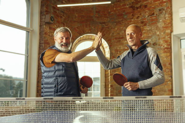 istock Senior men playing table tennis in workplace, having fun 1187124227