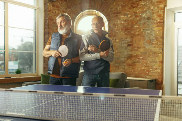 istock Senior men playing table tennis in workplace, having fun 1187124228
