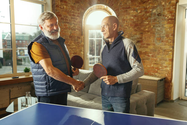 istock Senior men playing table tennis in workplace, having fun 1187124232