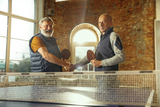 istock Senior men playing table tennis in workplace, having fun 1187124236