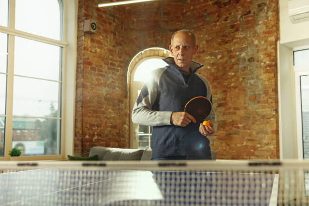 istock Senior man playing table tennis in workplace, having fun 1187124247