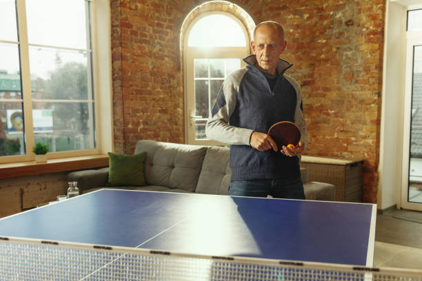 istock Senior man playing table tennis in workplace, having fun 1187124248