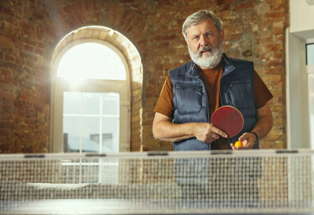 istock Senior man playing table tennis in workplace, having fun 1187124258