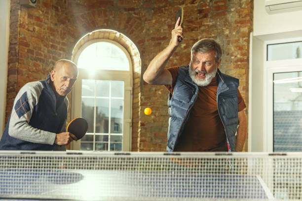 istock Senior men playing table tennis in workplace, having fun 1187124272