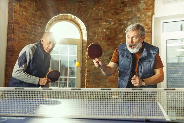 istock Senior men playing table tennis in workplace, having fun 1187124280