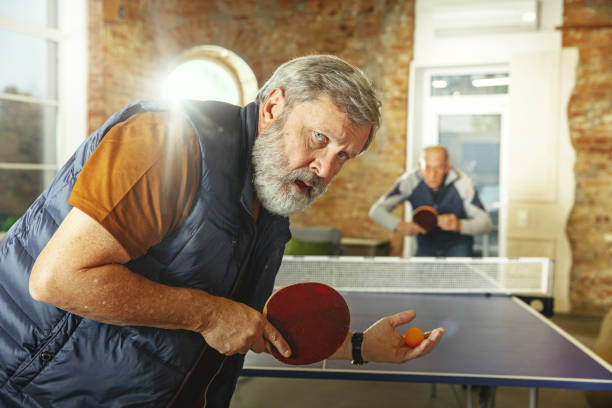 istock Senior men playing table tennis in workplace, having fun 1187124293