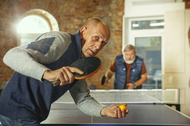 istock Senior men playing table tennis in workplace, having fun 1187124302
