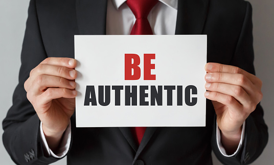 Businessman holding a card with text Be Authentic