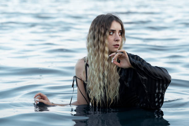 istock Beautiful Young Woman Looking Away While Standing In Sea 1187128184