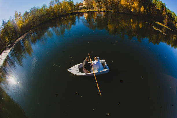 istock Beautiful young wedding couple on small boat sailing on a pond 1187131280