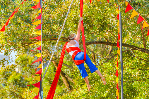 Young woman making fabric acrobatic technique at parque rodo park, montevideo, uruguay