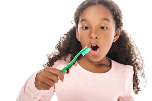 istock adorable african american kid brushing teeth isolated on white 1187135078