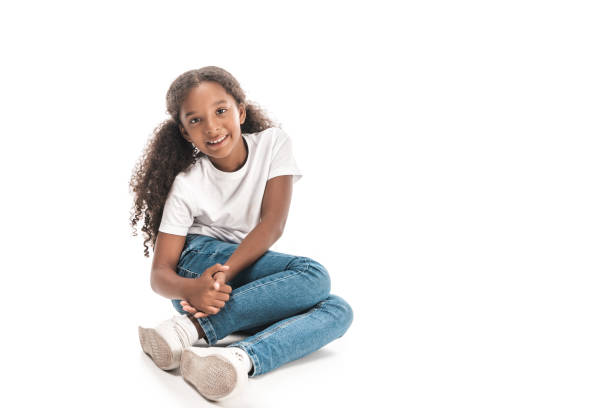 istock cheerful african american child smiling at camera while sitting on white background 1187135095
