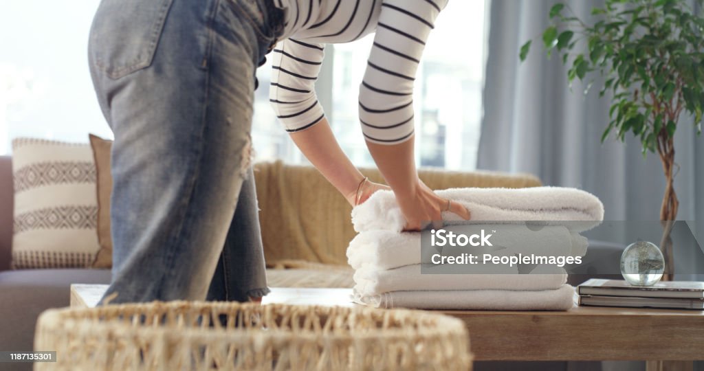 These will get me through the week Cropped shot of an unrecognizable woman folding up clean towels at home Laundry Stock Photo