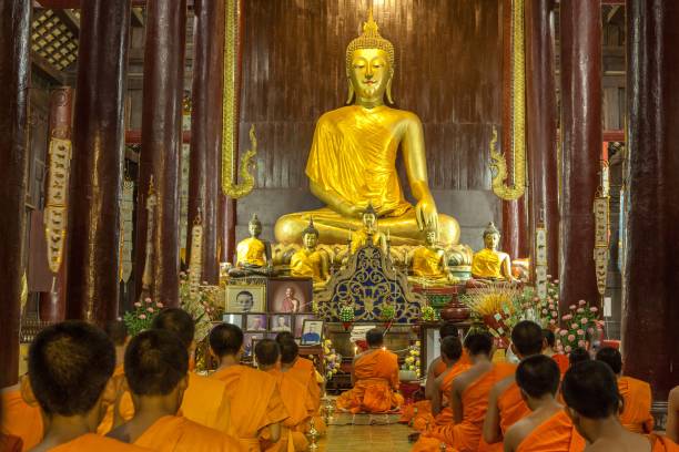 monjes budistas meditando frente a la imagen de buda en el templo de phan tao. - cántico fotografías e imágenes de stock
