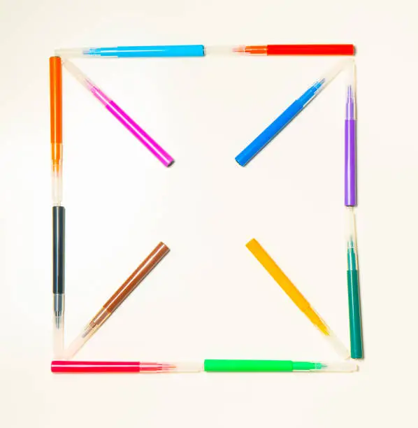 Colorful felt-tip pens on the white background. Markers pattern in the shape of square. Background or texture. Place fot text.