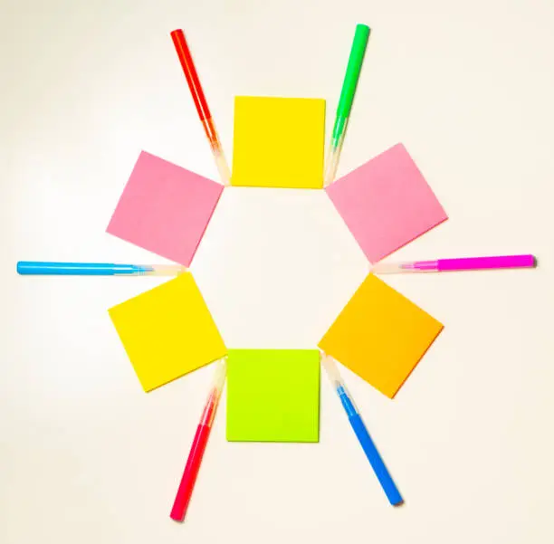 Colorful felt-tip pens on the white background. Markers and stickers pattern in the shape of star. Background or texture.