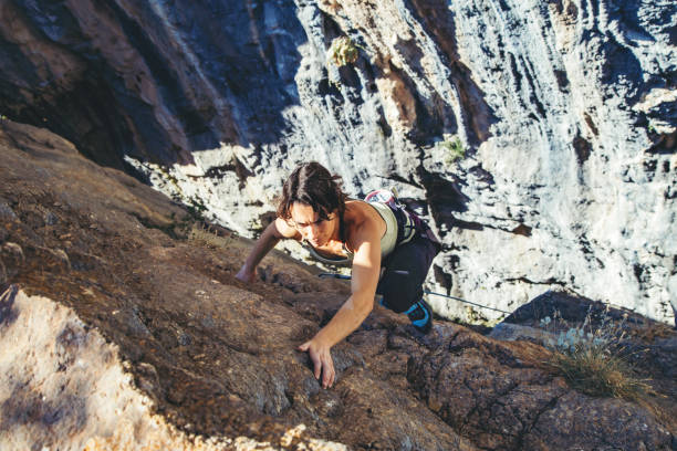 istock Woman climbs a rock. 1187139855