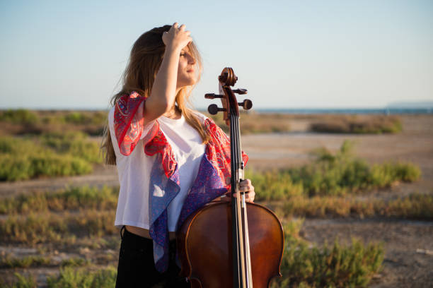 istock Young beautiful girl with her cello on the outside 1187141073