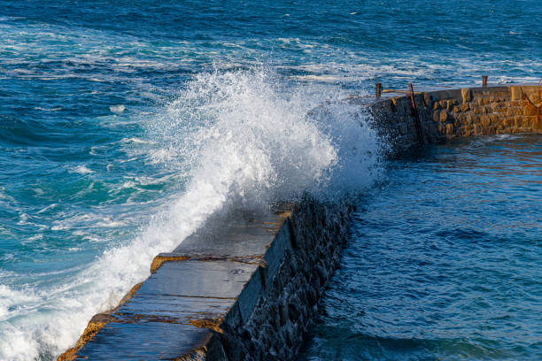 istock Water spraying over the wall at Sennen, Cornwall 1187142236