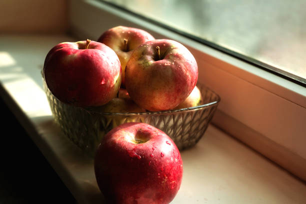 istock Autumn apples lie in a transparent Cup on the windowsill 1187142474