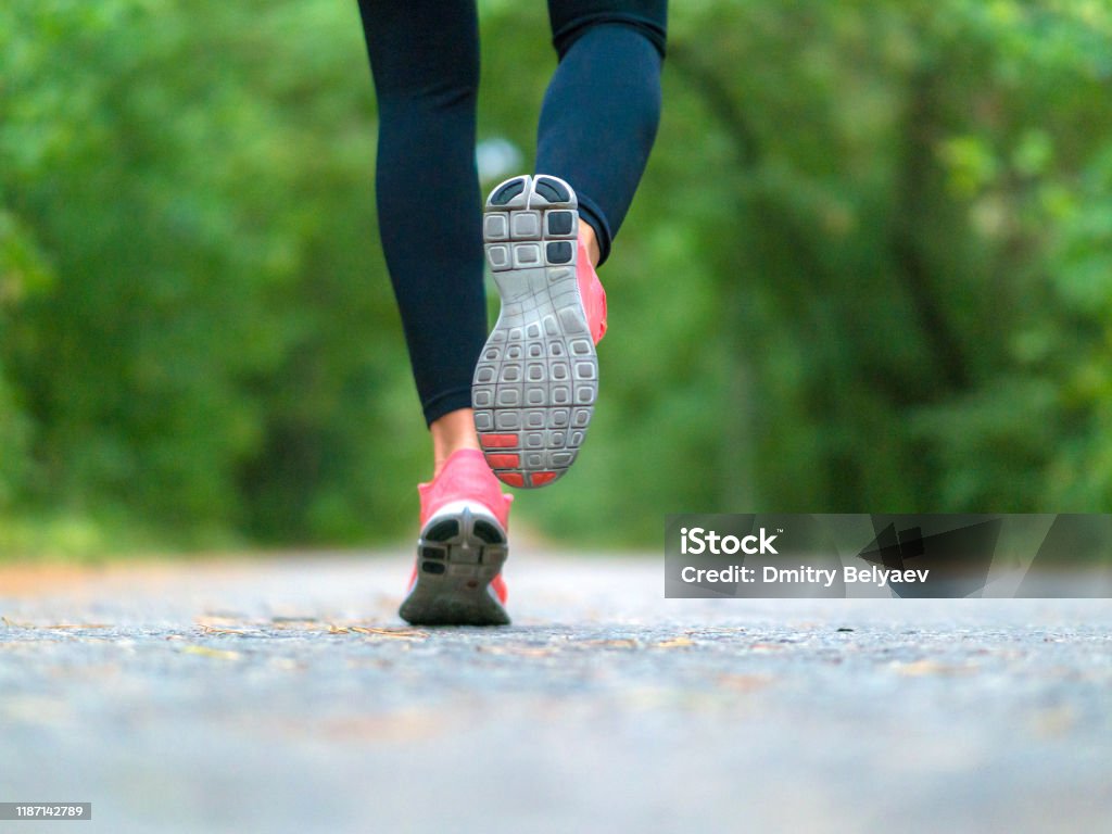 Mujer corriendo en el bosque. Primer plano de las zapatillas. - Foto de stock de Correr libre de derechos