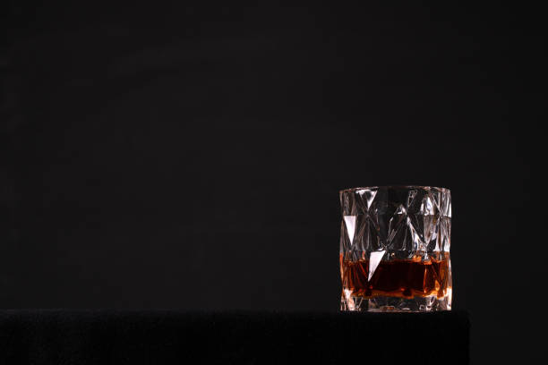 istock Glass with whiskey on black background 1187143405