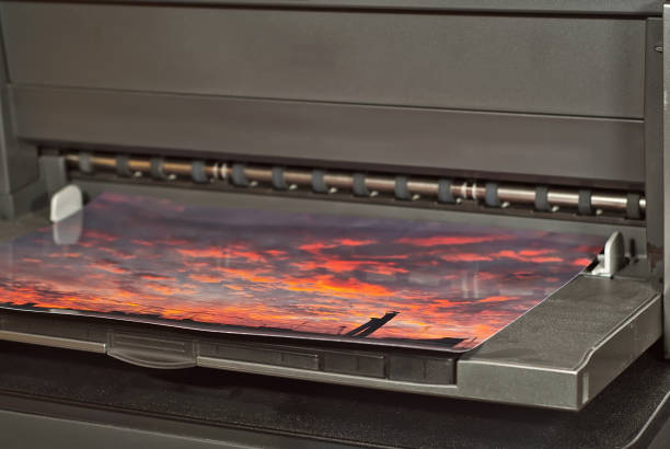 old broken printer in workshop. the concept of cleaning and calibrating printers. sunset and red sky with clouds in the photo. picturesque nature photo printed on printing equipment. - photobusiness imagens e fotografias de stock