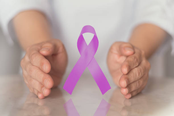 concept de journée mondiale du cancer. mains retenant le ruban de conscience pourpre pour l'épilepsie nationale,lupus ,alzheimer, crohn, maladie de fibromyalgia et course - hodgkins disease photos et images de collection