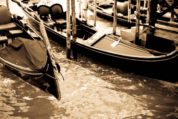 Venice Gondola close-up of the prow at the of front the gondola against the green of the canal.