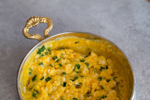 istock Scrambled eggs with cheese and spring onion. Served in a copper pan. 1187148037