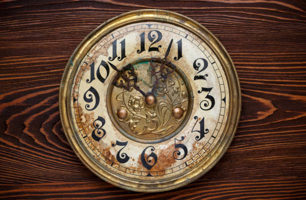 istock Old clock with a rusty clock face on wooden background. 1187148073