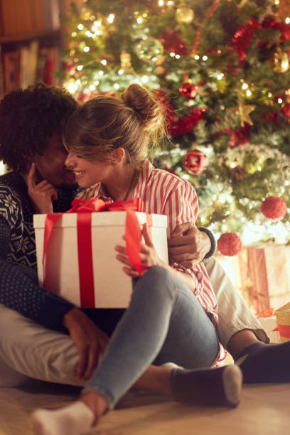istock Young couple opening a present on a Christmas 1187148237