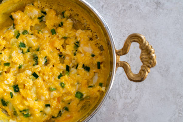 istock Scrambled eggs with cheese and spring onion. Served in a copper pan. 1187148375