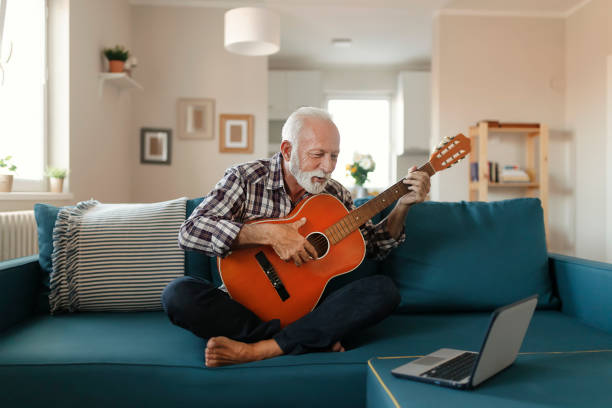 istock Senior Man Learns to Play Acoustic Guitar Online 1187149090