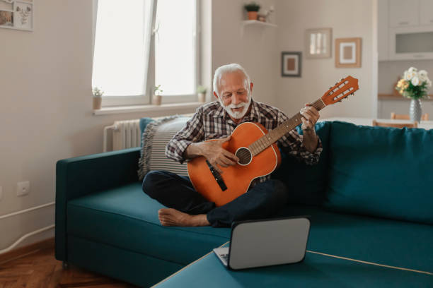 istock Senior Man Learns to Play Acoustic Guitar Online 1187149137