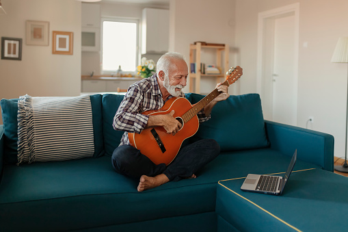 Senior Man Learns to Play Acoustic Guitar Online