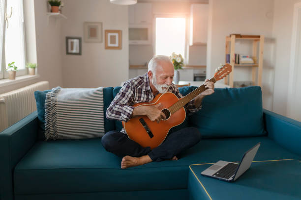 istock Senior Man Learns to Play Acoustic Guitar Online 1187149148