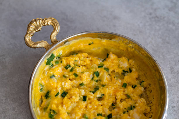 istock Scrambled eggs with cheese and spring onion. Served in a copper pan. 1187151521