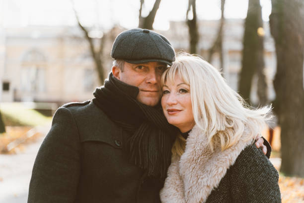 ritratto ravvicinato di donna matura bionda felice e bella bruna di mezza età, guardando direttamente la fotocamera. coppia amorevole di passeggiate di 45-50 anni nel parco autunnale in abiti caldi - 40 45 years immagine foto e immagini stock