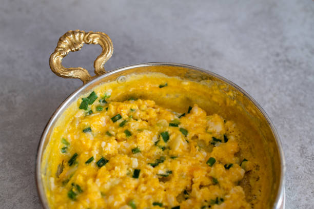 istock Scrambled eggs with cheese and spring onion. Served in a copper pan. 1187153353