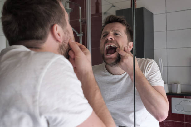 istock young man in the bathroom checking his teeth 1187157422