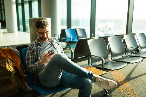 istock Passenger Waiting for flight at airport and text messaging 1187160737