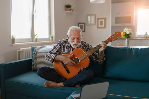 istock Senior Man Learns to Play Acoustic Guitar Online 1187162469