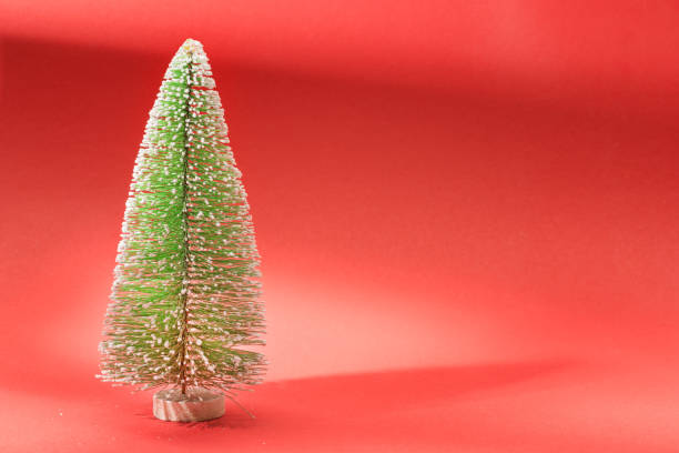 istock Small red artificial Christmas fir on red background 1187171986